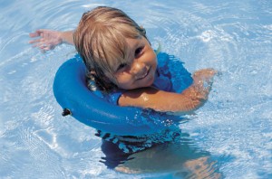 Young girl floating in swimming pool with innertube